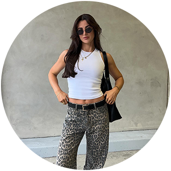 Woman with blonde hair wearing jeans and a white halter top