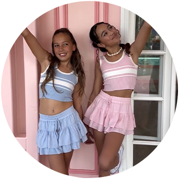 Woman in a bright pink bikini set posing on the beach in front of the water